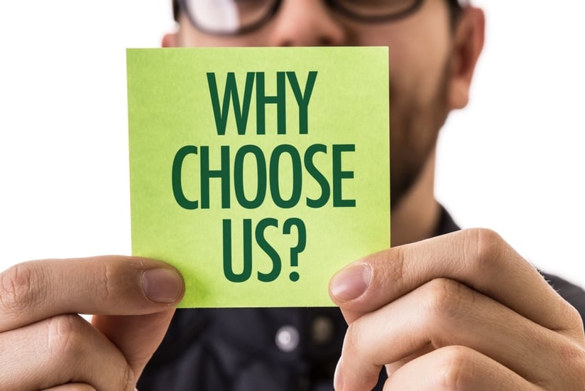 someone holding a sticky note that says why choose us?